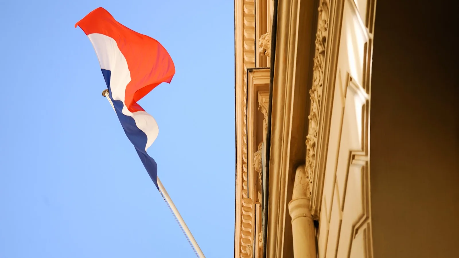Drapeau français flottant sur une façade illustrant les chaînes françaises en IPTV