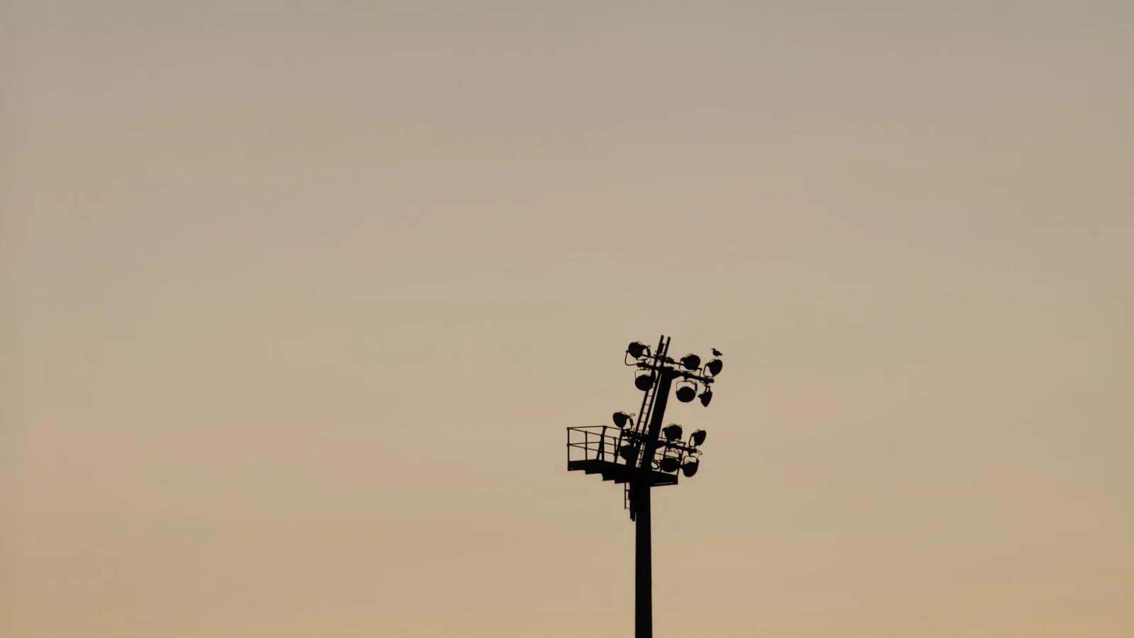 Projecteurs de stade en silhouette au coucher du soleil illustrant la Ligue des Champions en IPTV