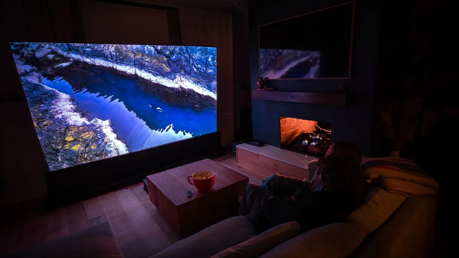 Deux personnes installées devant un grand écran illustrant l'offre IPTV films et séries