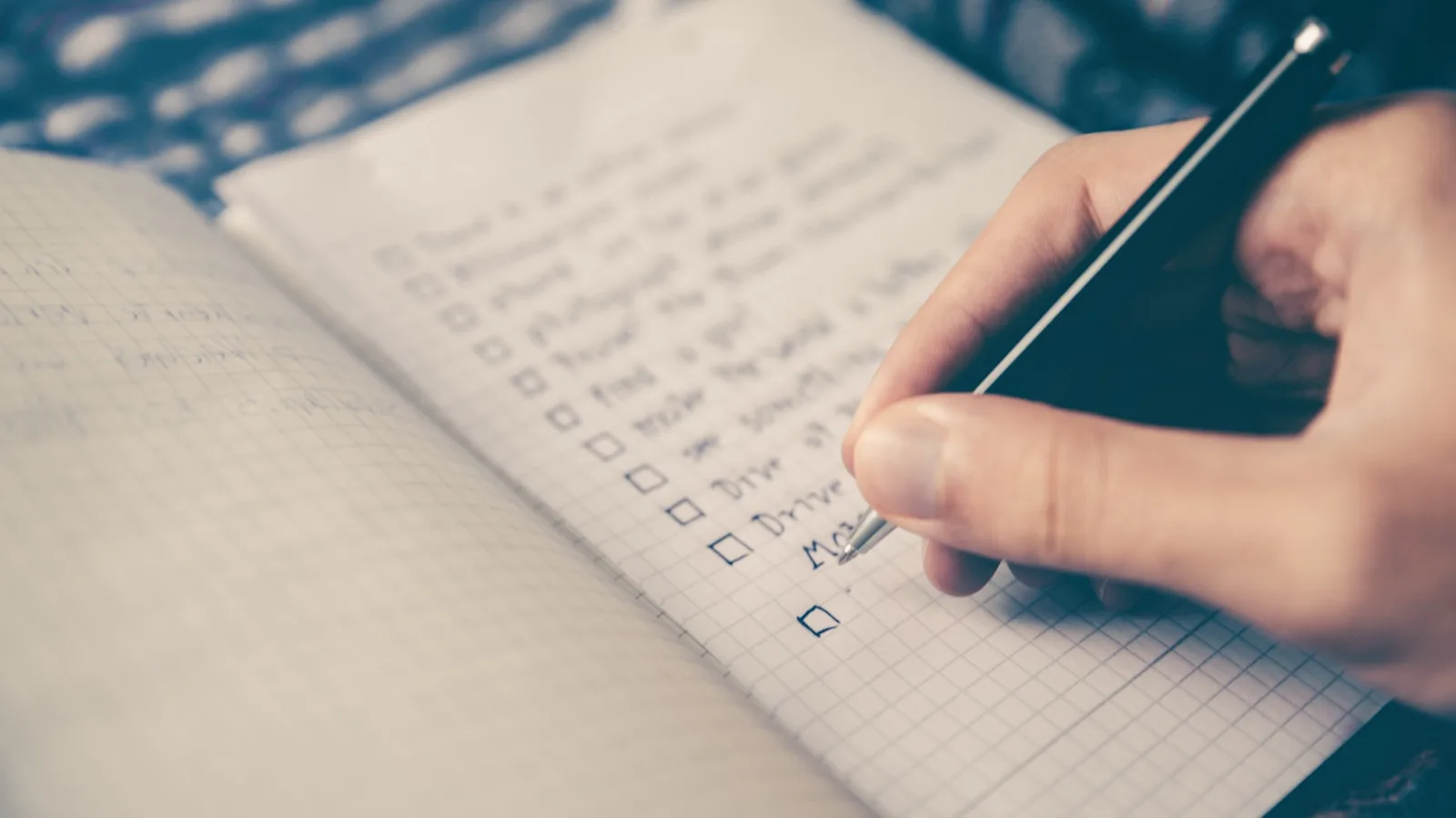 Personne notant des critères sur un carnet illustrant le choix d'un service IPTV