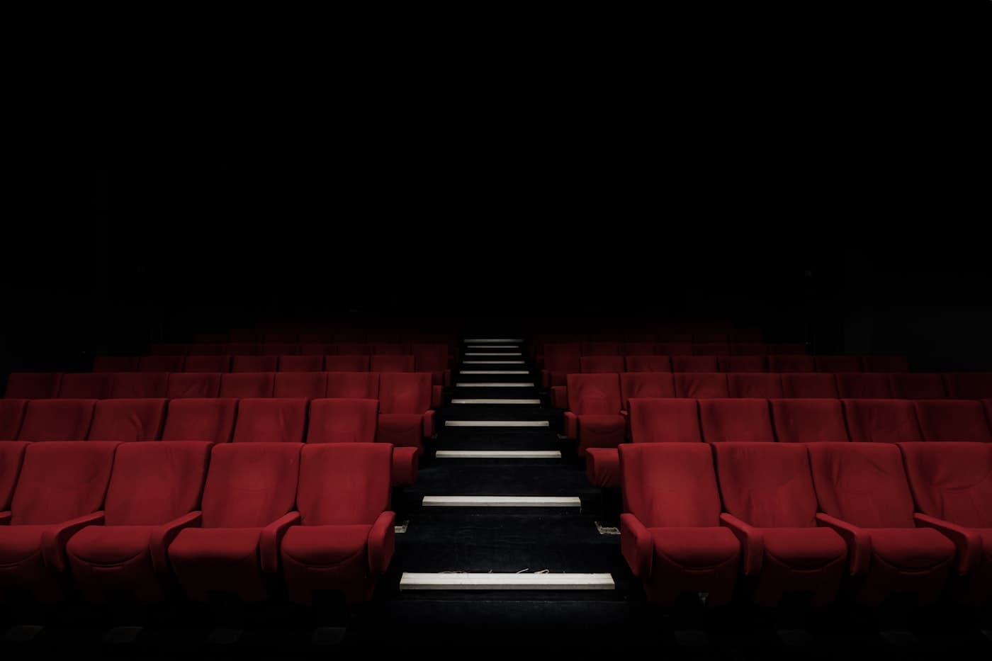 Empty cinema hall with premium red seating representing 8K Ultra HD picture quality